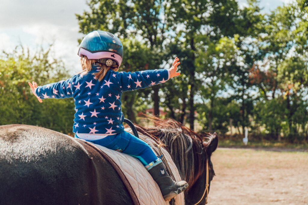 young girl having fun learning to ride horses