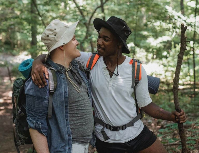 a couple in a romantic relationship taking a hike through a tree-filled area