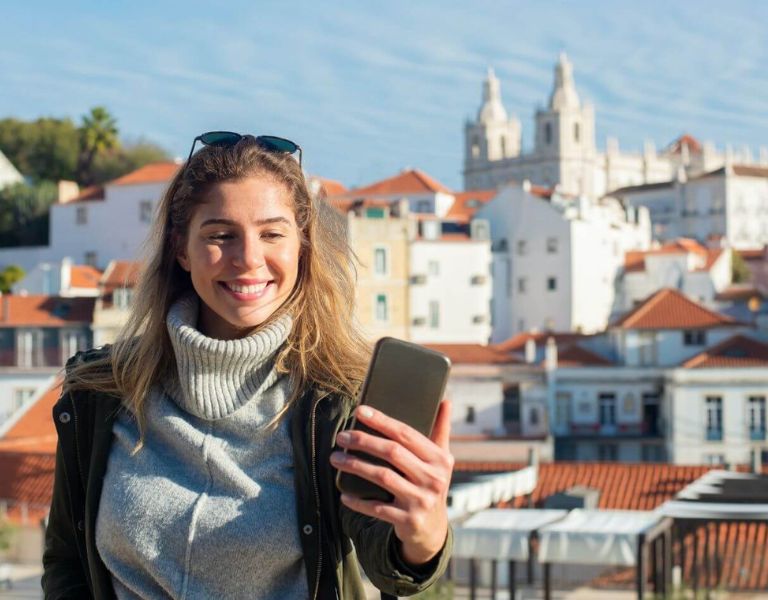 A female solo traveller taking a selfie with a picturesque background